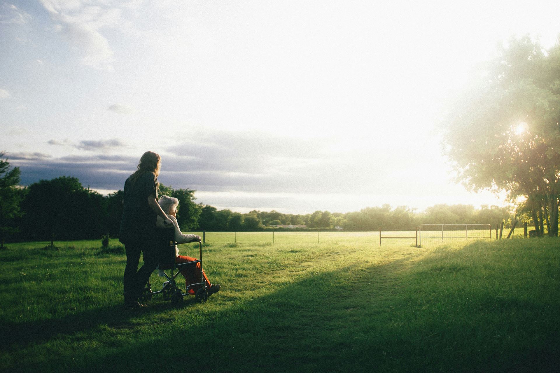 Woman in wheel chair in the park with carer